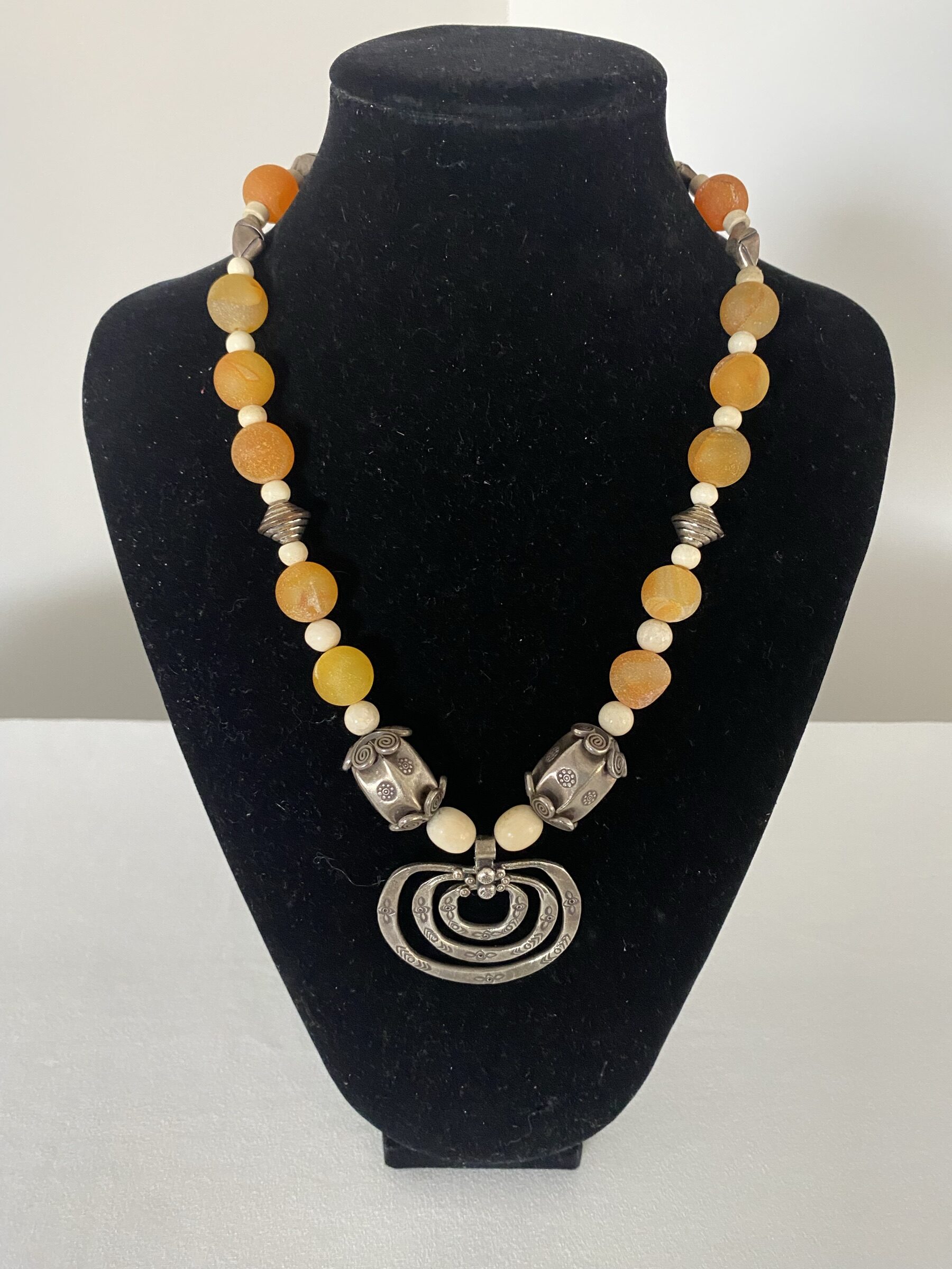 3 Ring Sterling Pendant by Naga By Nevara — three-ring sterling pendant with origami silver and apricot quartz, 50cm.