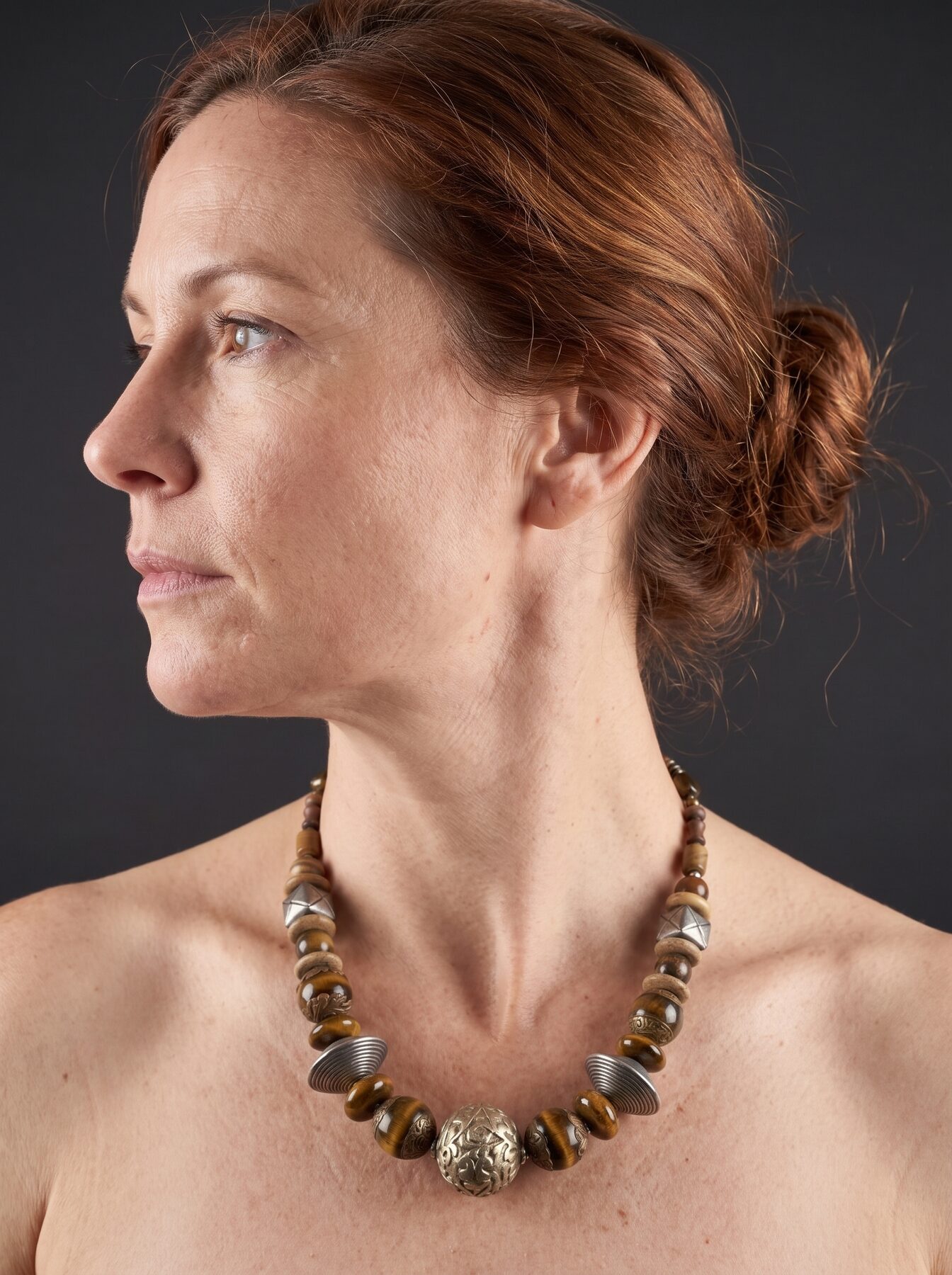 African Tiger Eye necklace by Naga By Nevara worn by a model, profile view — tiger eye, antique silver and brass beads