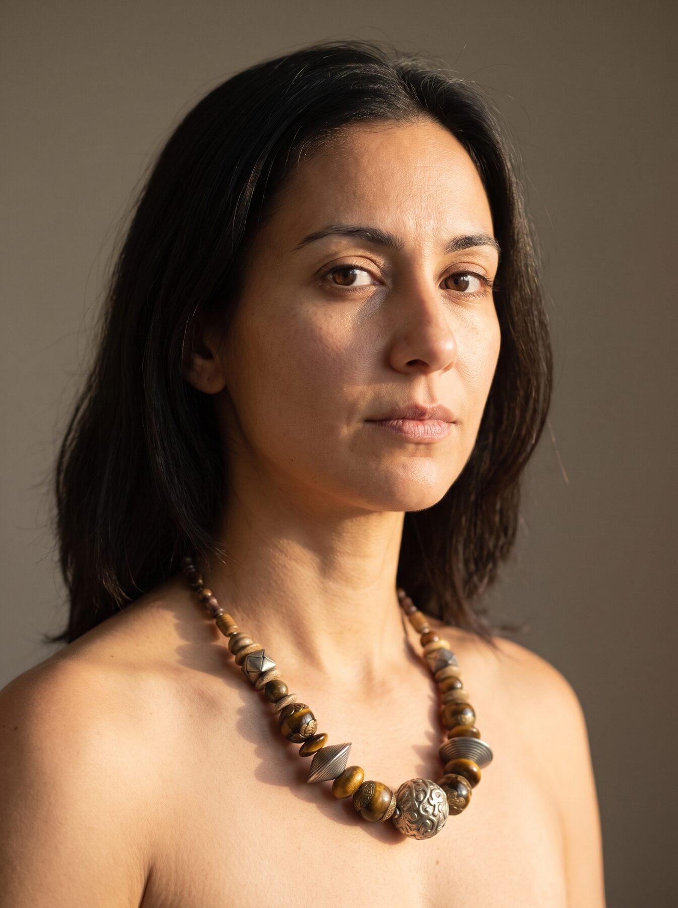 African Tiger Eye necklace by Naga By Nevara worn by a model, three-quarter view — tiger eye, antique silver and brass beads