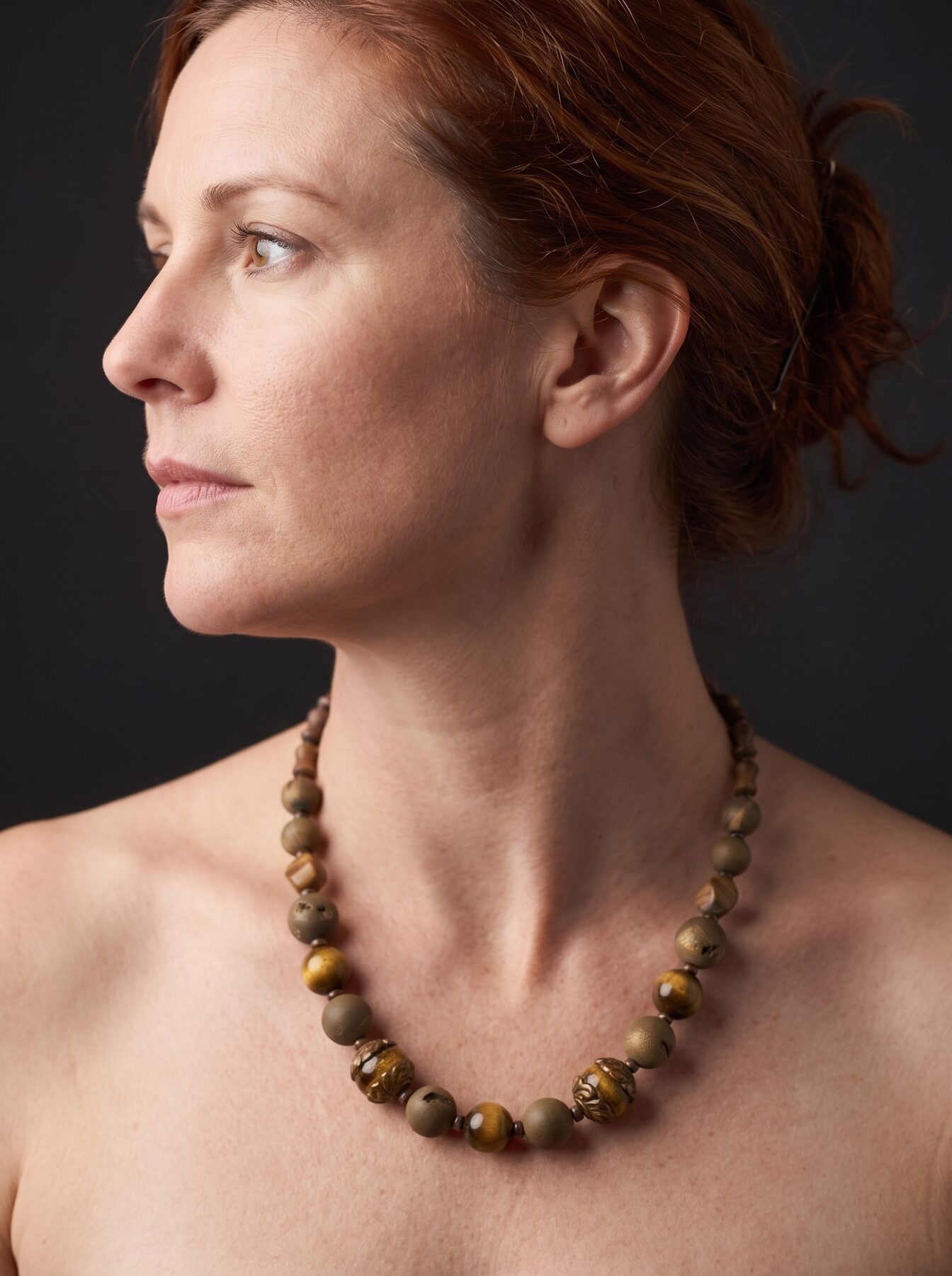Antique Tiger Eye necklace by Naga By Nevara worn by a model, profile view